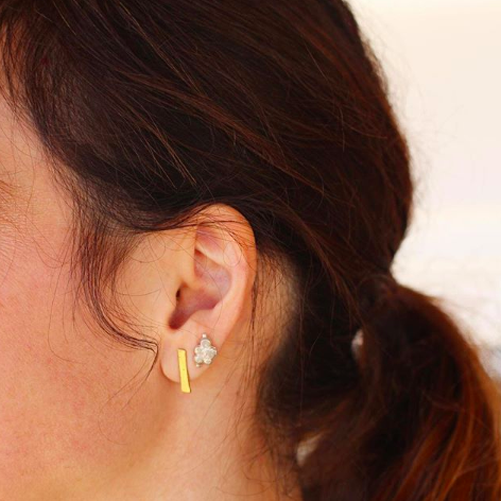 close up ear gold bar stud earring and cluster stud